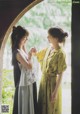 A couple of women standing next to each other near an archway.