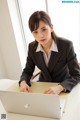 A woman sitting at a desk using a laptop computer.