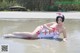 A woman in a nurse outfit laying in the water.