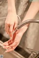 A woman's hands washing her hands under a faucet.