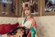 A woman in a kimono sitting on a white couch.