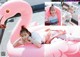 A woman laying on top of a pink flamingo float.