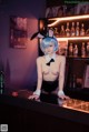 A woman in bunny ears sitting at a bar.