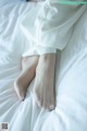 A woman laying on top of a bed with her feet up.