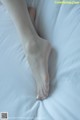 A close up of a woman's bare feet on a bed.