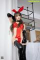 A woman in a red and black bunny costume posing for a picture.