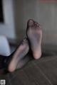 A pair of black stockings sitting on top of a wooden floor.