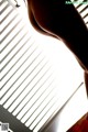 A woman standing in front of a window with blinds.