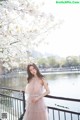 A woman in a pink dress standing on a bridge.