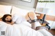 A woman laying on a bed in a white shirt and black stockings.