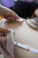 A woman is putting a bandage on her back.