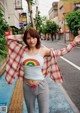 A woman standing on the side of a street with her arms outstretched.