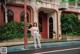 A woman standing in front of a red brick building.