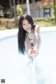 A woman in a bikini standing in a swimming pool.