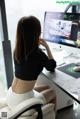 A woman sitting at a desk in front of a computer.