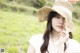 A woman wearing a straw hat in a field.