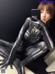 A woman in a black and silver spider suit taking a selfie.