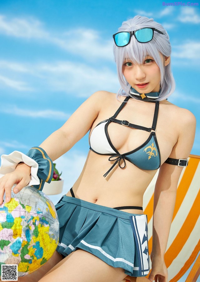 A woman in a bikini sitting on a beach chair holding a globe.