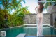 A woman in a white dress standing in a pool.