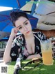 A woman sitting at a table with a glass of orange juice.