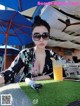 A woman sitting at a table with a glass of orange juice.